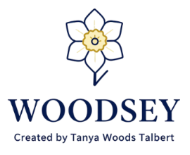 A logo-style graphic on a white background featuring a stylized flower above the word 'WOODSEY' in large navy text, with smaller text reading 'Created by Tanya Woods Talbert' underneath.